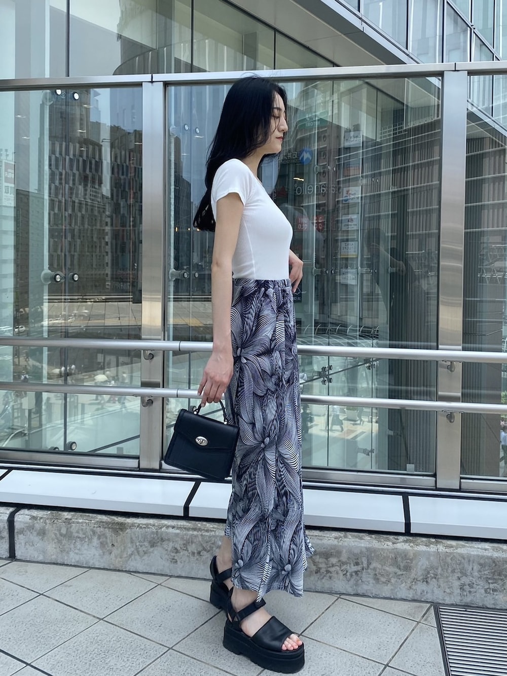 ブラック系のサンダル、ブラック系のハンドバッグ、その他のスカートを着用したレディースの夏コーディネートの3枚目の写真