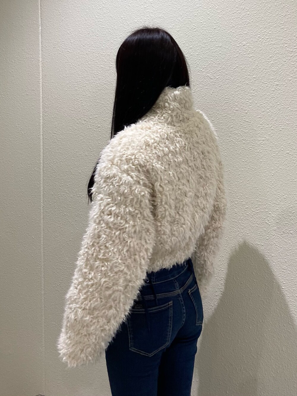 ブルー系のデニムパンツ、ホワイト系のブルゾンを着用したレディースの秋コーディネートの6枚目の写真