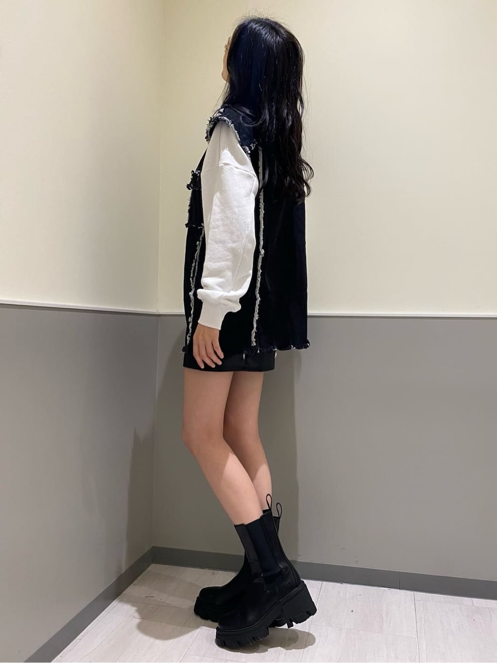 ブラック系のブーツ、ブラック系のデニムジャケット、ホワイト系のスウェットを着用したレディースの秋コーディネートの2枚目の写真