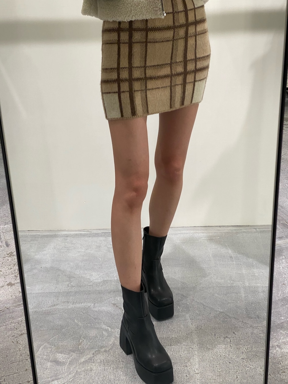 ベージュ系のニット/セーター、ベージュ系のスカート、ブラック系のブーツを着用したレディースの冬コーディネートの8枚目の写真