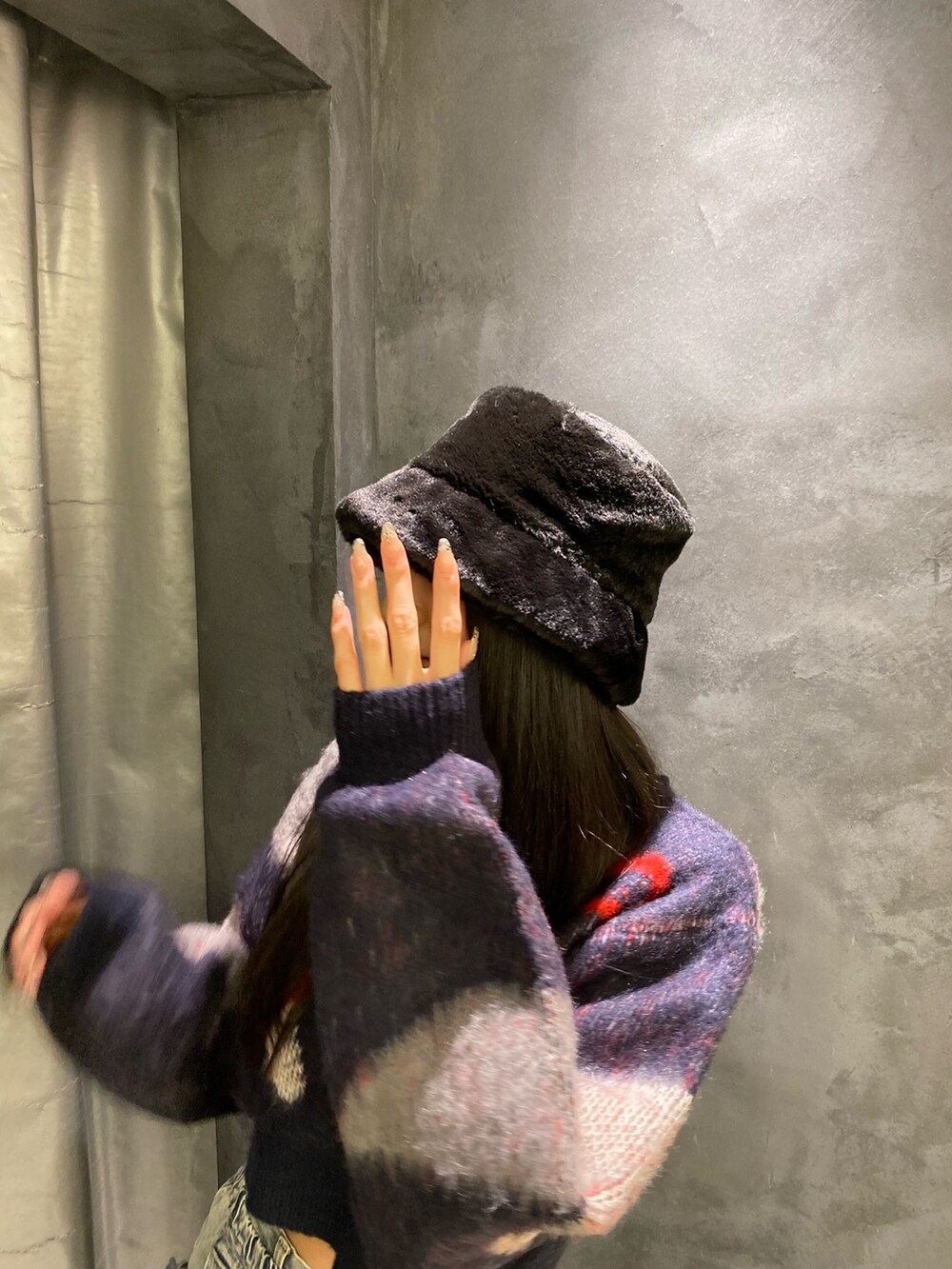 ブルー系のデニムパンツ、ブルー系のニット/セーター、ブラック系のブーツを着用したレディースの秋コーディネートの6枚目の写真