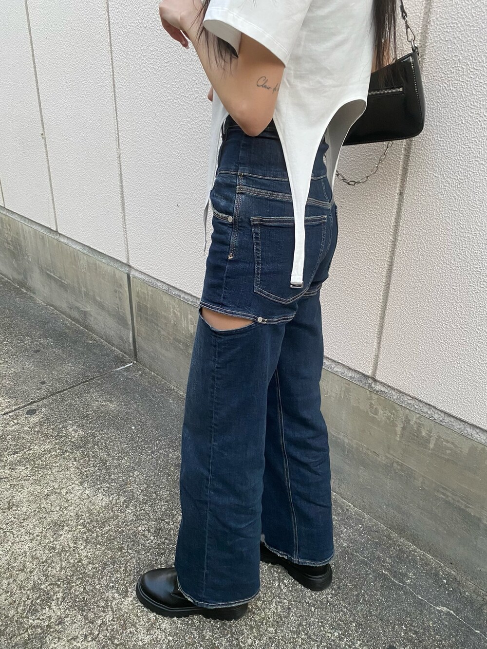 ブルー系のデニムパンツ、ブラック系のショルダーバッグ、ホワイト系のTシャツ/カットソーを着用したレディースの春コーディネートの9枚目の写真