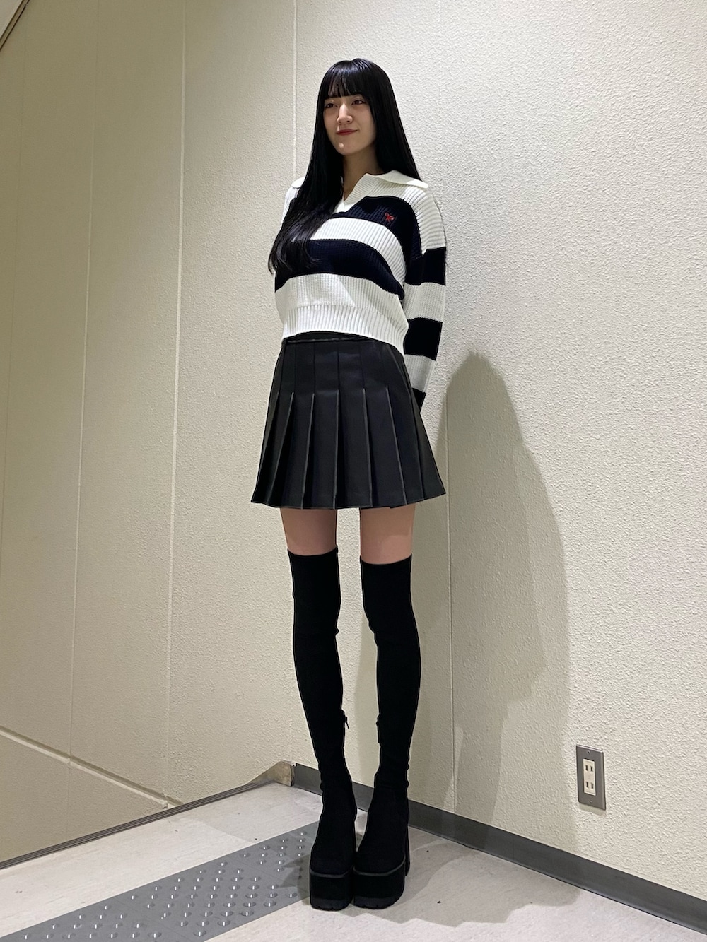 ブラック系のスカート、その他のニット/セーター、ブラック系のブーツを着用したレディースの冬コーディネートの2枚目の写真