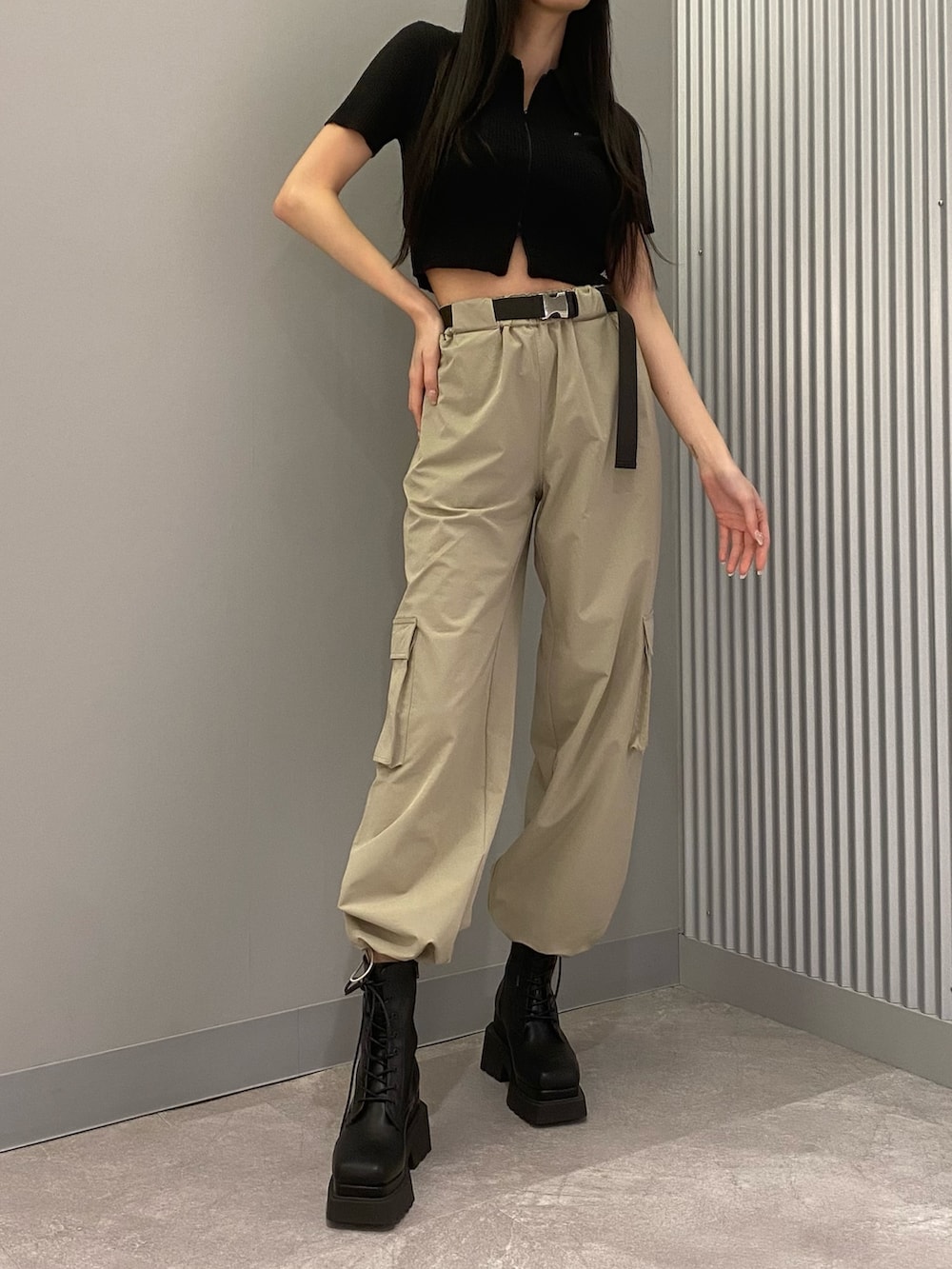 ベージュ系のカーゴパンツ、ブラック系のニット/セーター、ブラック系のブーツを着用したレディースの春コーディネートの3枚目の写真