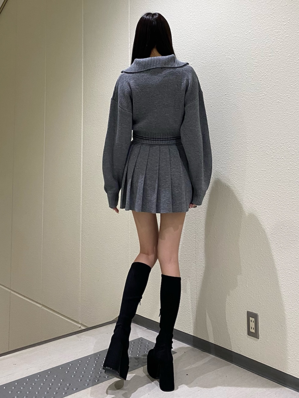 グレー系のニット/セーター、グレー系のスカート、その他のブーツを着用したレディースの秋コーディネートの2枚目の写真