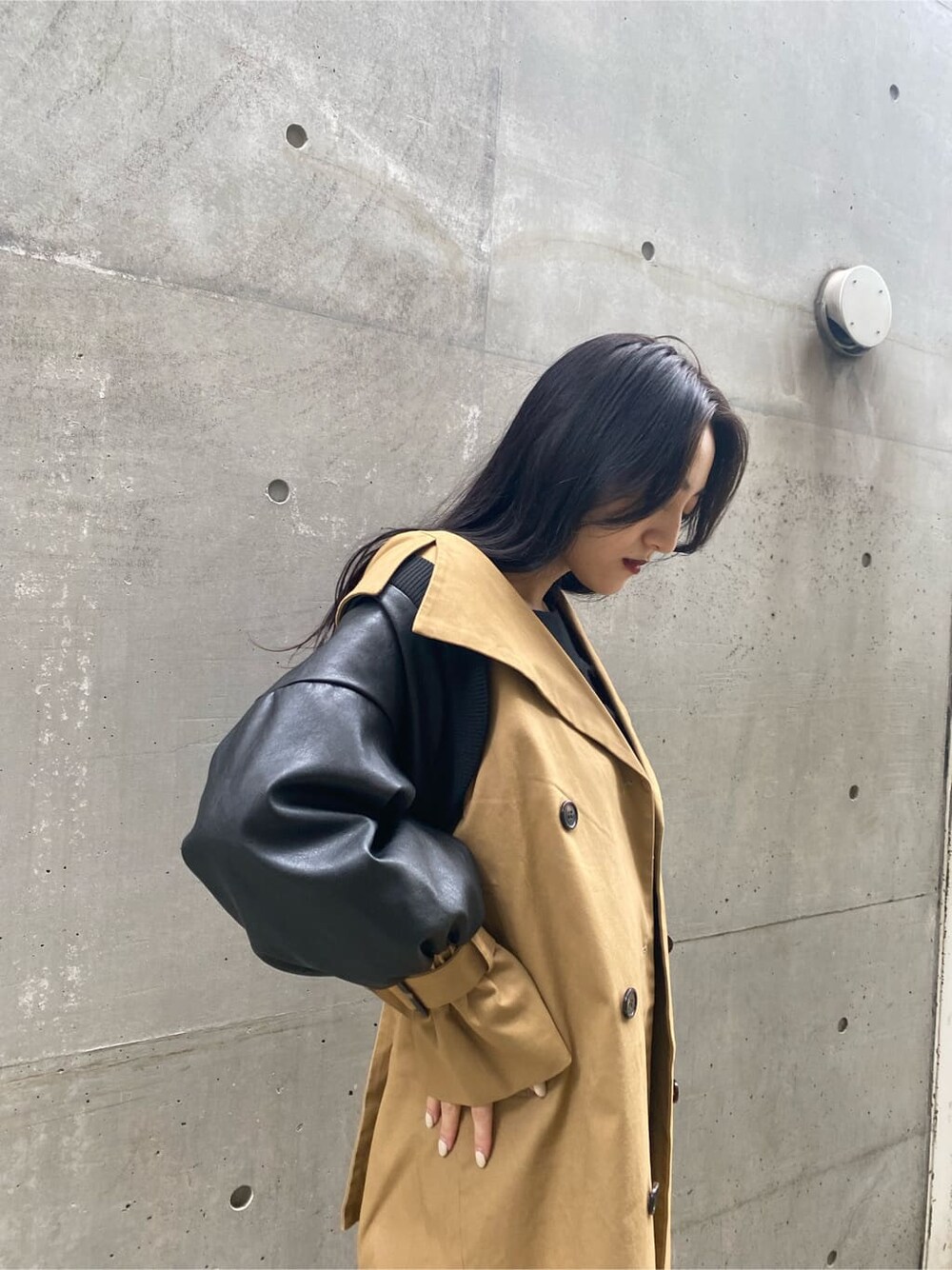 ブルー系のデニムパンツ、ベージュ系のトレンチコート、ブラック系のニット/セーターを着用したレディースの秋コーディネートの4枚目の写真