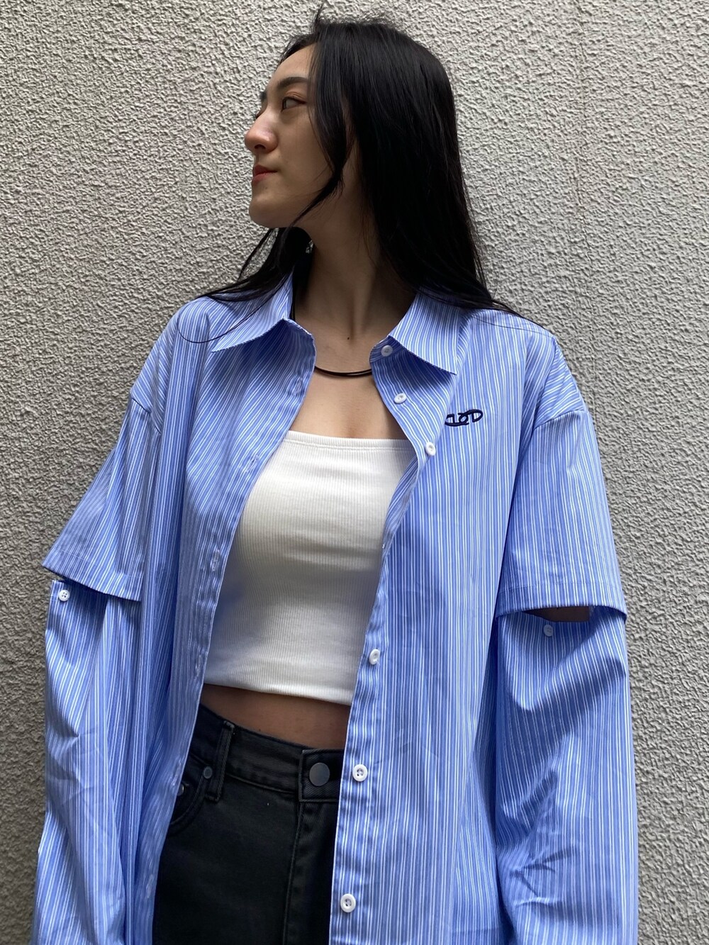 ブラック系のデニムパンツ、ブラック系のハンドバッグ、ブラック系のブーツを着用したレディースの春コーディネートの4枚目の写真