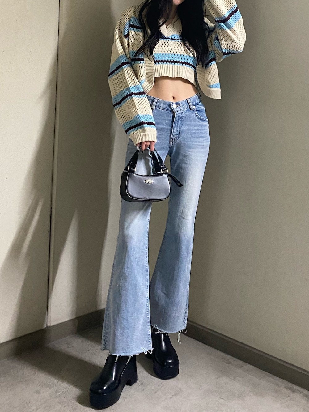 その他のニット/セーター、ブルー系のデニムパンツ、ブラック系のハンドバッグを着用したレディースの春コーディネートの2枚目の写真