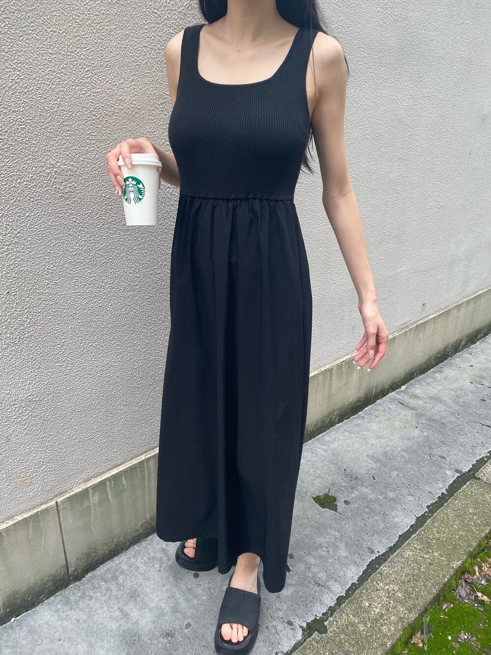 ブラック系のワンピース、ブラック系のサンダル、ホワイト系のハットを着用したレディースの夏コーディネートの7枚目の写真