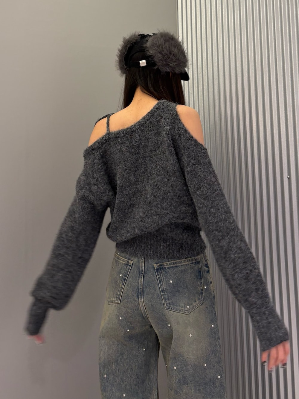 ブルー系のデニムパンツ、グレー系のニット/セーター、ブラック系のブーツを着用したレディースの冬コーディネートの8枚目の写真