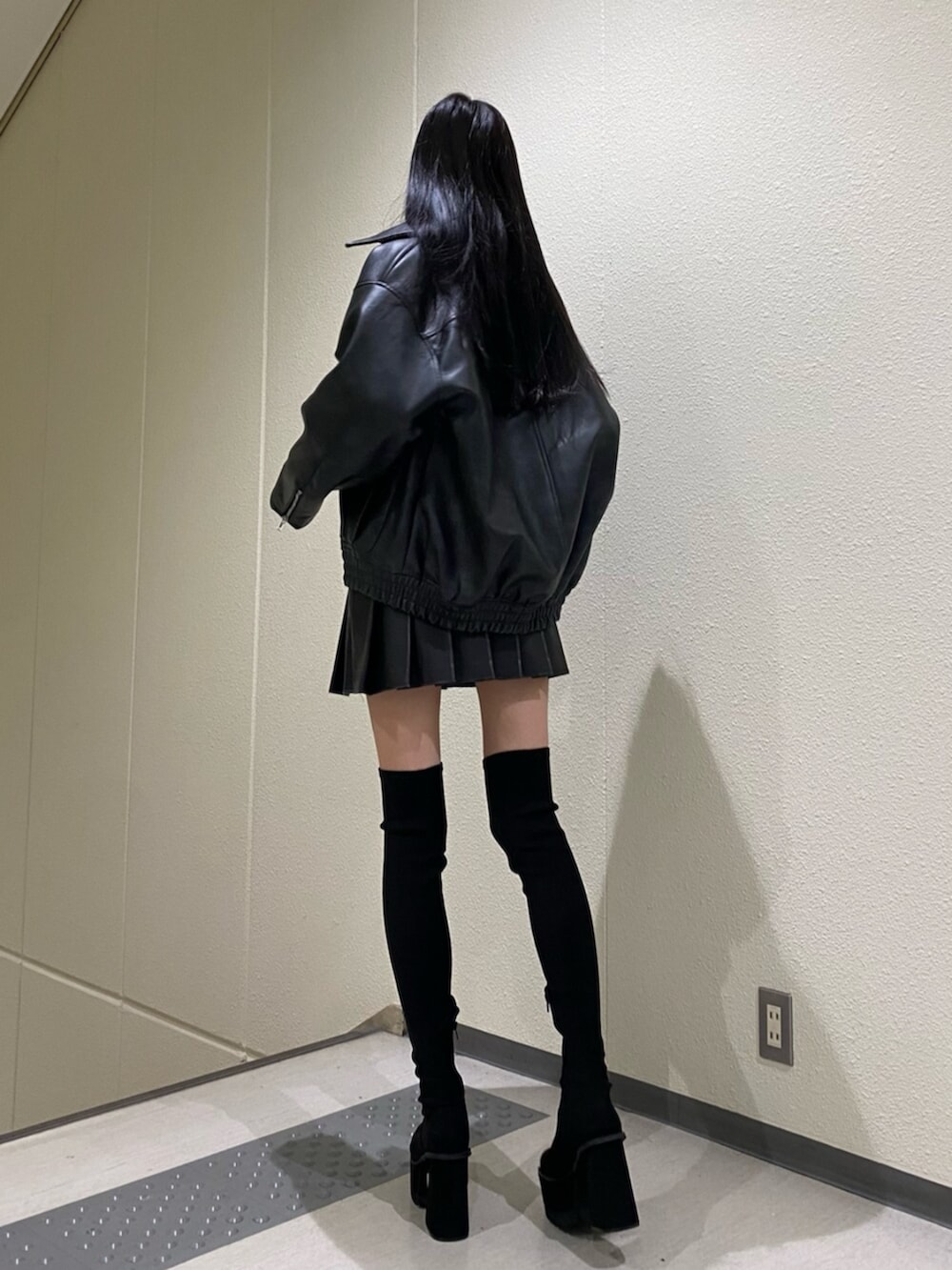 ブラック系のスカート、その他のニット/セーター、ブラック系のブーツを着用したレディースの冬コーディネートの4枚目の写真