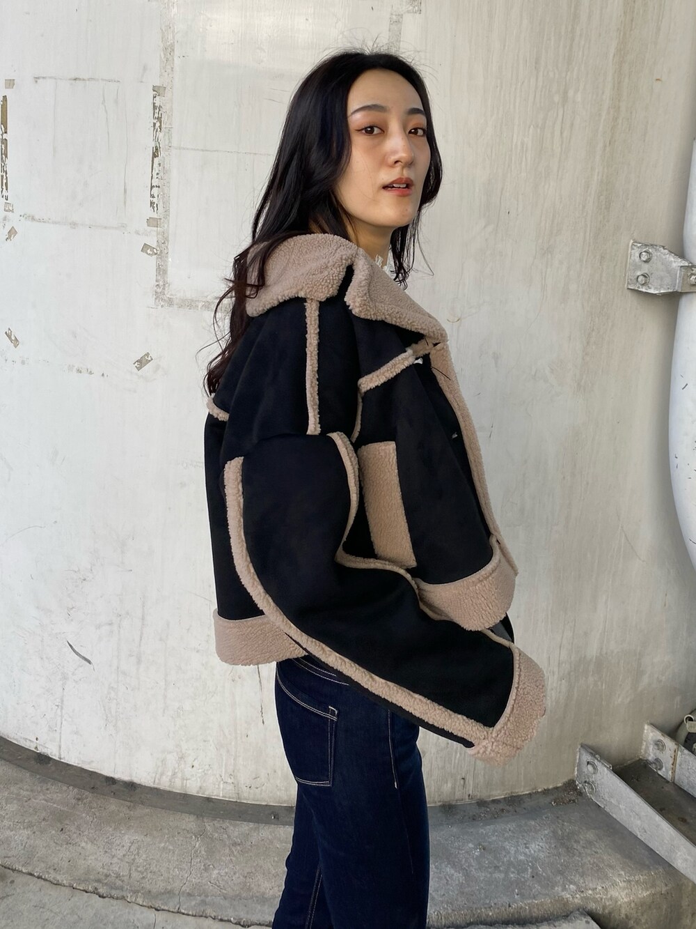 ブルー系のデニムパンツ、ブラック系のムートンコート、ホワイト系のニット/セーターを着用したレディースの秋コーディネートの7枚目の写真