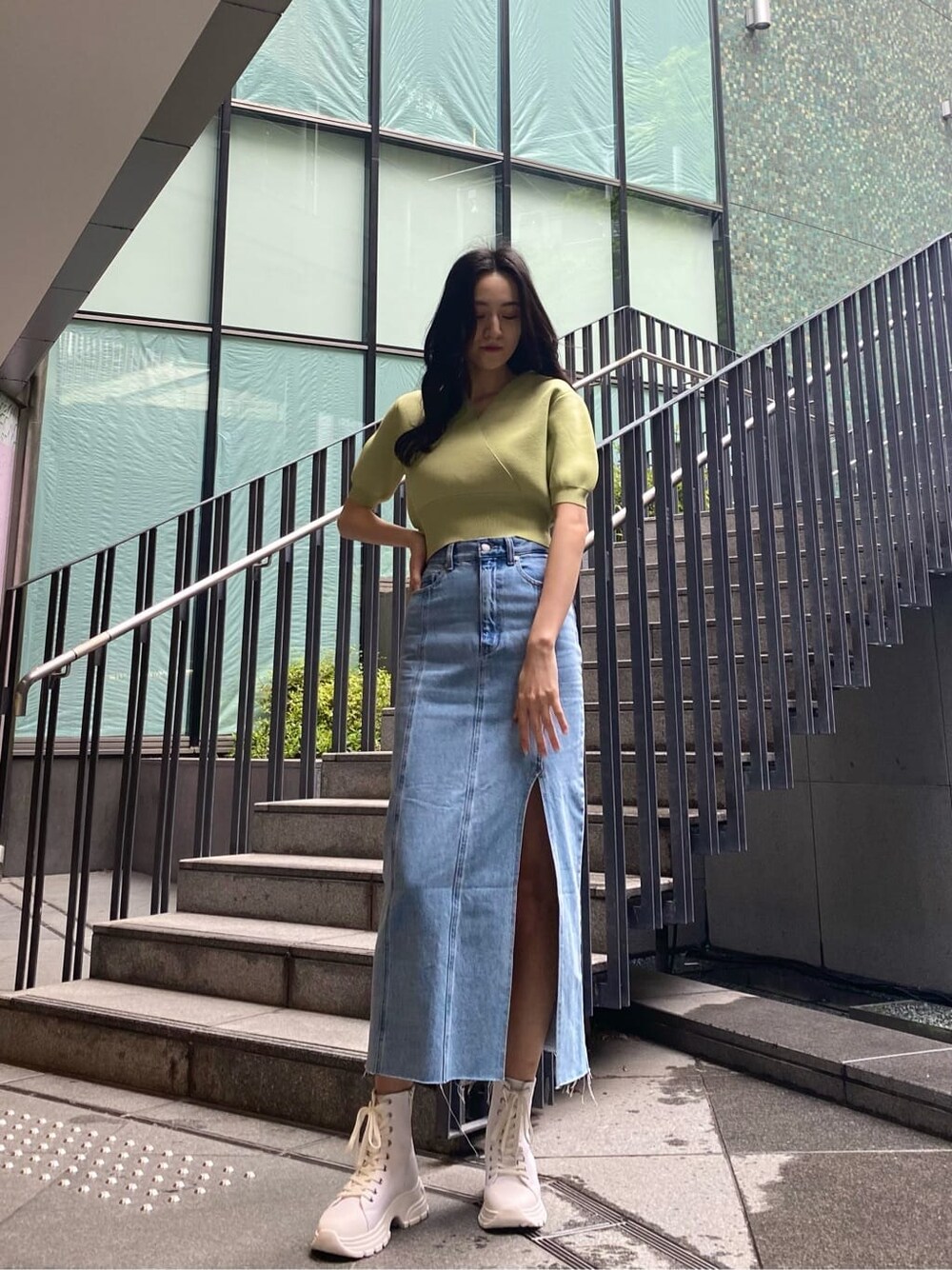 ブルー系のスカート、ホワイト系のスニーカー、イエロー系のニット/セーターを着用したレディースの春コーディネートの2枚目の写真