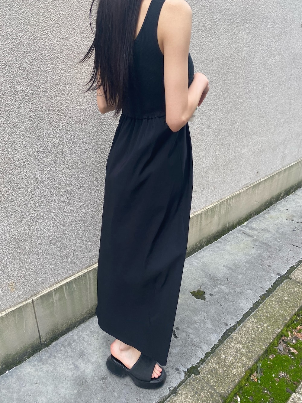 ブラック系のワンピース、ブラック系のサンダル、ホワイト系のハットを着用したレディースの夏コーディネートの8枚目の写真