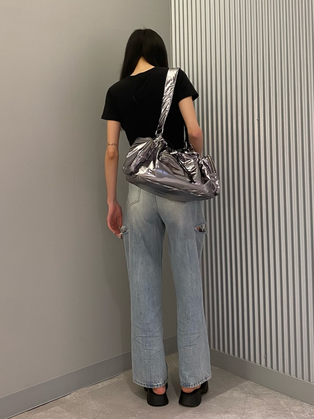 ブラック系のTシャツ/カットソー、ブラック系のサンダル、ブルー系のデニムパンツを着用したレディースの夏コーディネートの3枚目の写真