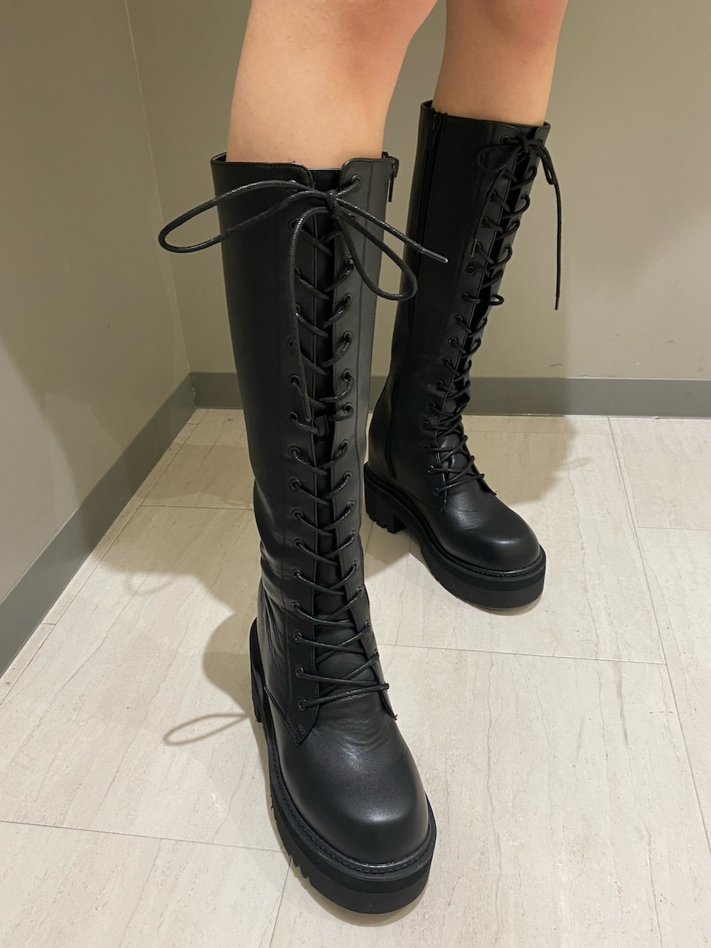 ブラック系のスカート、ピンク系のニット/セーター、ホワイト系のダウンベストを着用したレディースの秋コーディネートの6枚目の写真