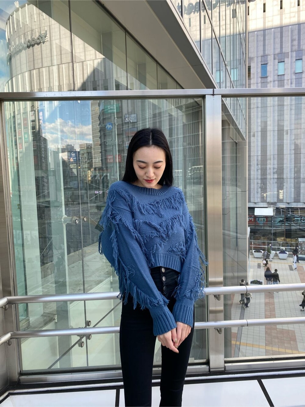 ブラック系のデニムパンツ、ブラック系のダウンジャケット/コート、ブルー系のニット/セーターを着用したレディースの冬コーディネートの3枚目の写真