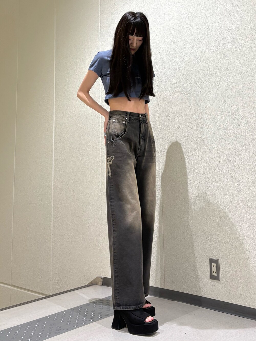 ブラック系のデニムパンツ、ブルー系のTシャツ/カットソー、ブラック系のサンダルを着用したレディースの夏コーディネートの5枚目の写真