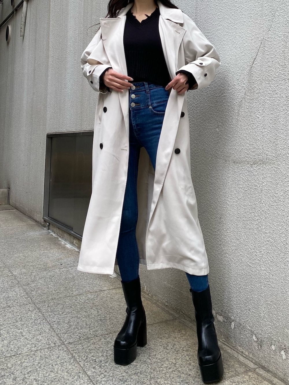 ブラック系のニット/セーター、ブルー系のデニムパンツ、ブラック系のブーツを着用したレディースの冬コーディネートの5枚目の写真