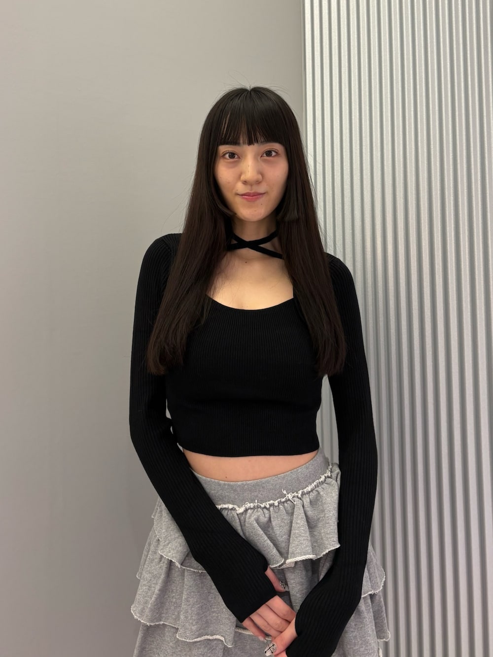 グレー系のスカート、ブラック系のニット/セーター、ブラック系のブーツを着用したレディースの秋コーディネートの5枚目の写真