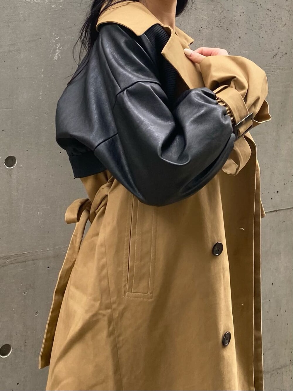 ブルー系のデニムパンツ、ベージュ系のトレンチコート、ブラック系のニット/セーターを着用したレディースの秋コーディネートの5枚目の写真