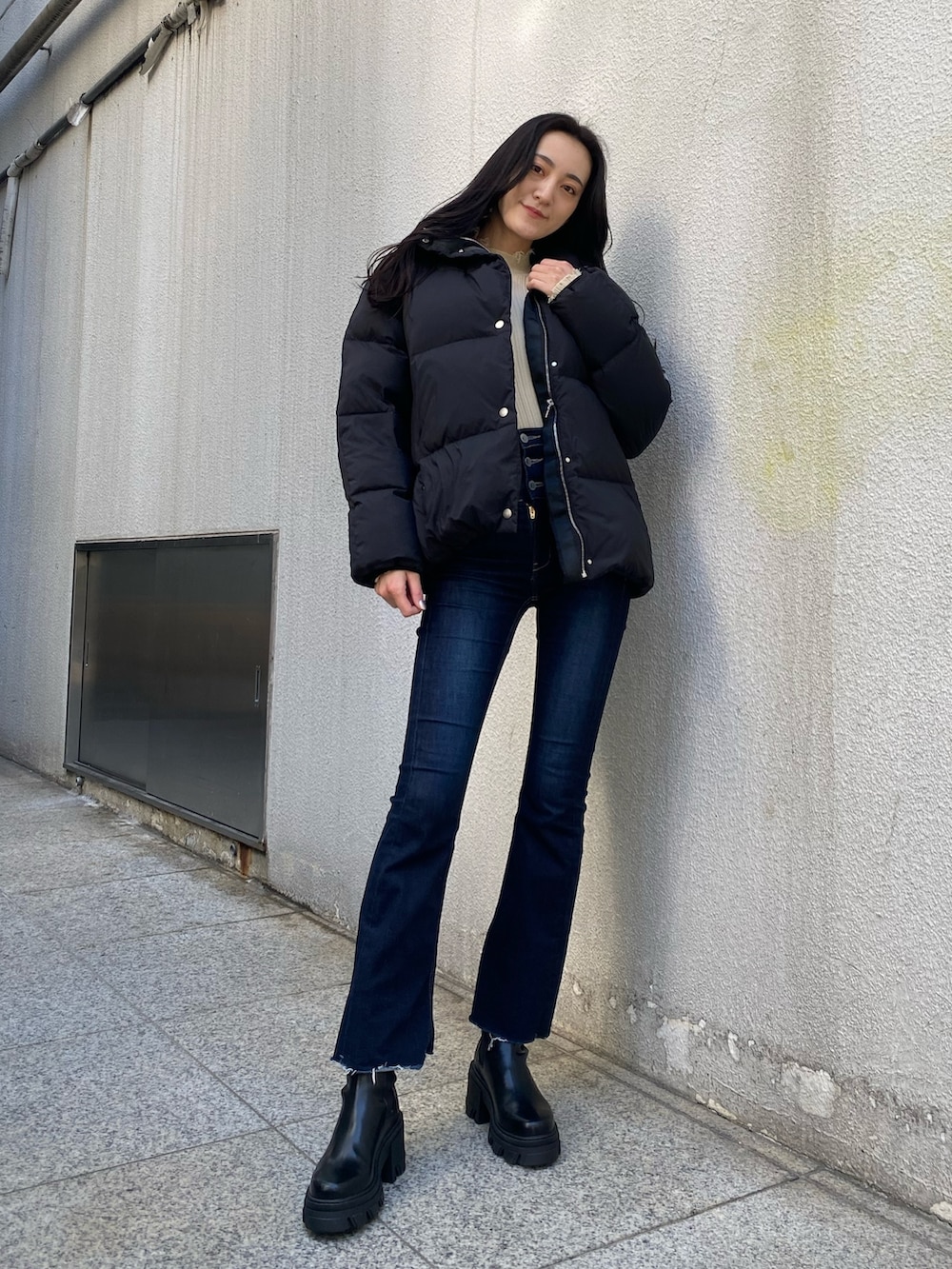 ブルー系のデニムパンツ、ホワイト系のニット/セーター、ブラック系のブーツを着用したレディースの冬コーディネートの2枚目の写真