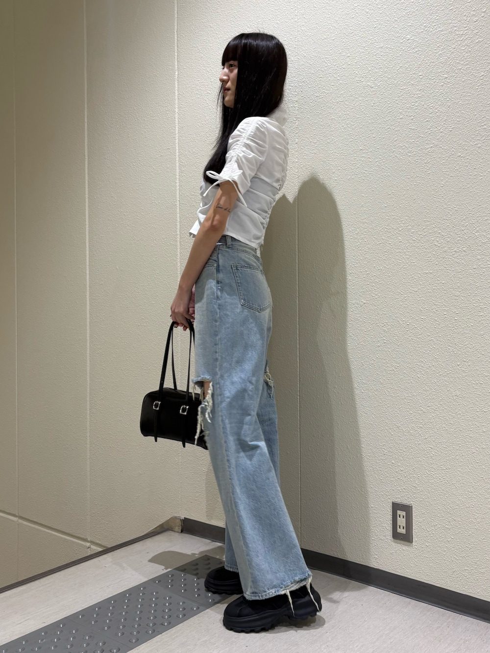 ブルー系のデニムパンツ、ホワイト系のシャツ/ブラウス、ブラック系のサンダルを着用したレディースの春コーディネートの2枚目の写真