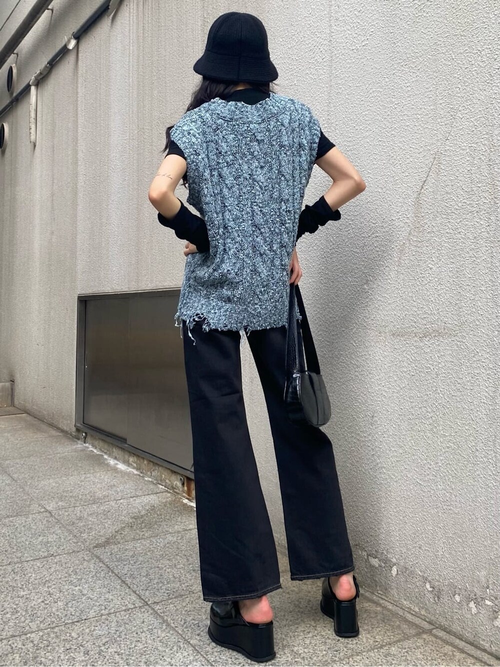 ブラック系のデニムパンツ、ブルー系のベスト、ブラック系のスリッポンを着用したレディースの夏コーディネートの3枚目の写真