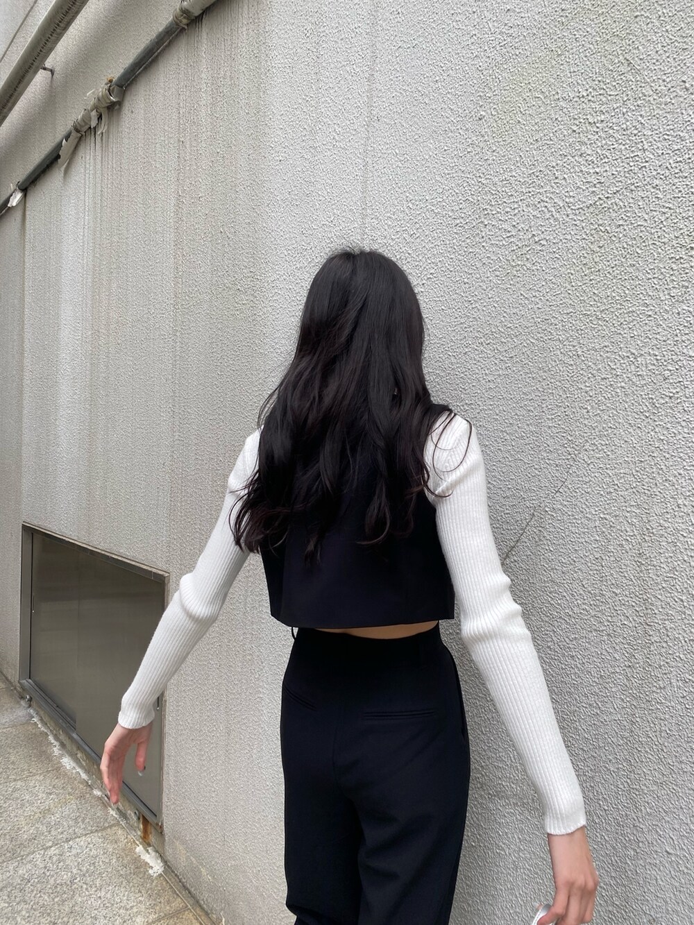 ブラック系のベスト、ブラック系のその他パンツ、ホワイト系のニット/セーターを着用したレディースの春コーディネートの6枚目の写真