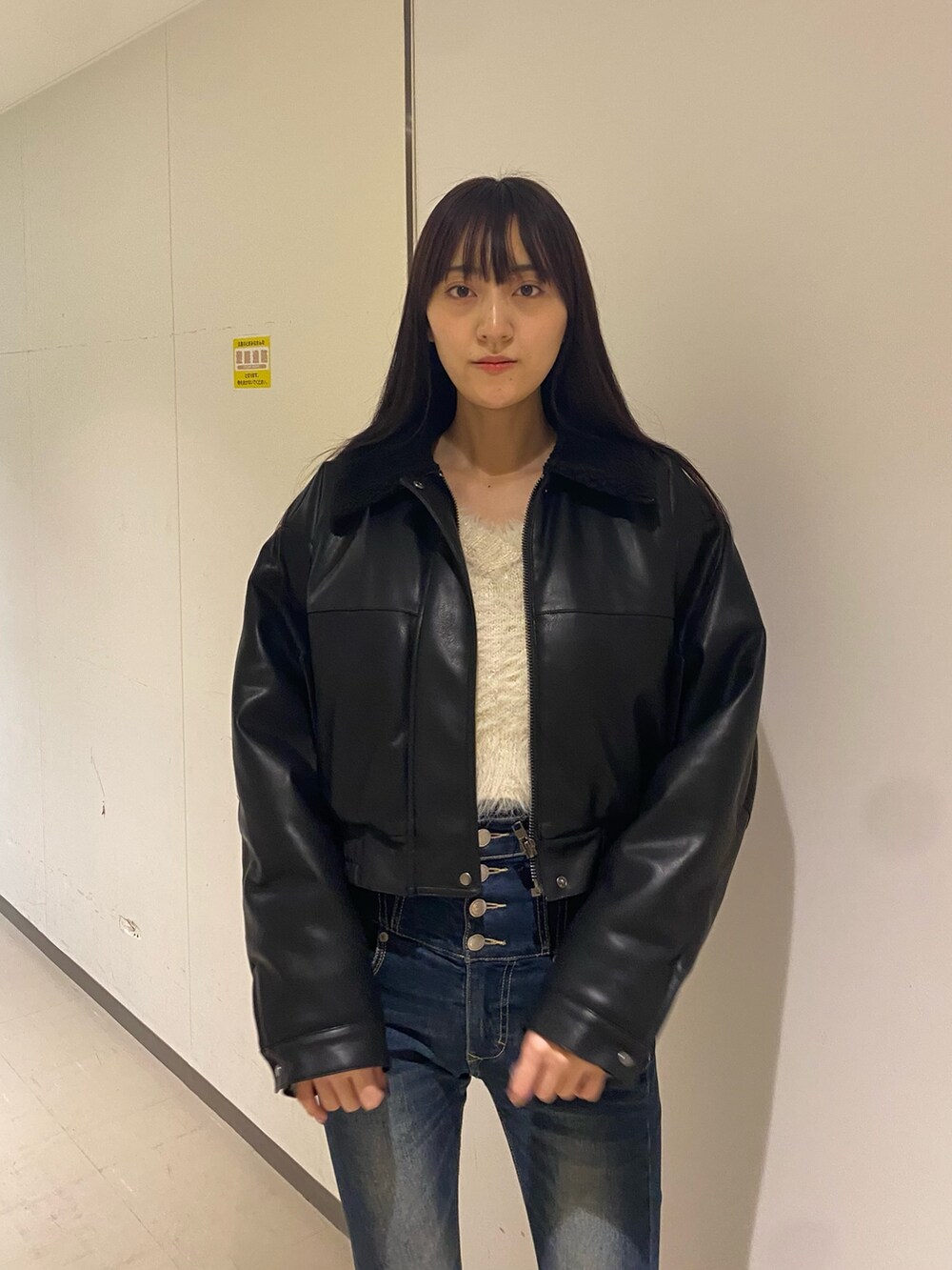 ブルー系のデニムパンツ、ホワイト系のニット/セーター、ブラック系のブルゾンを着用したレディースの秋コーディネートの4枚目の写真