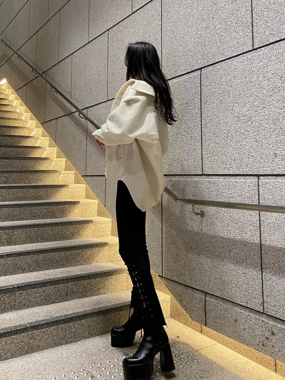 ホワイト系のブルゾン、ブルー系のニット/セーター、ブラック系のデニムパンツを着用したレディースの冬コーディネートの4枚目の写真