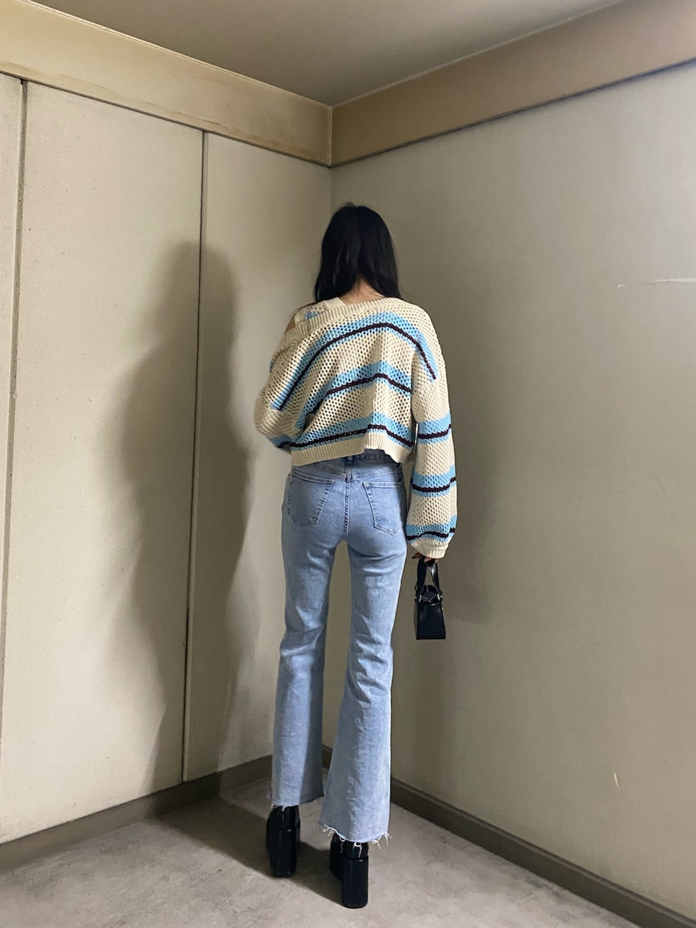 その他のニット/セーター、ブルー系のデニムパンツ、ブラック系のハンドバッグを着用したレディースの春コーディネートの4枚目の写真