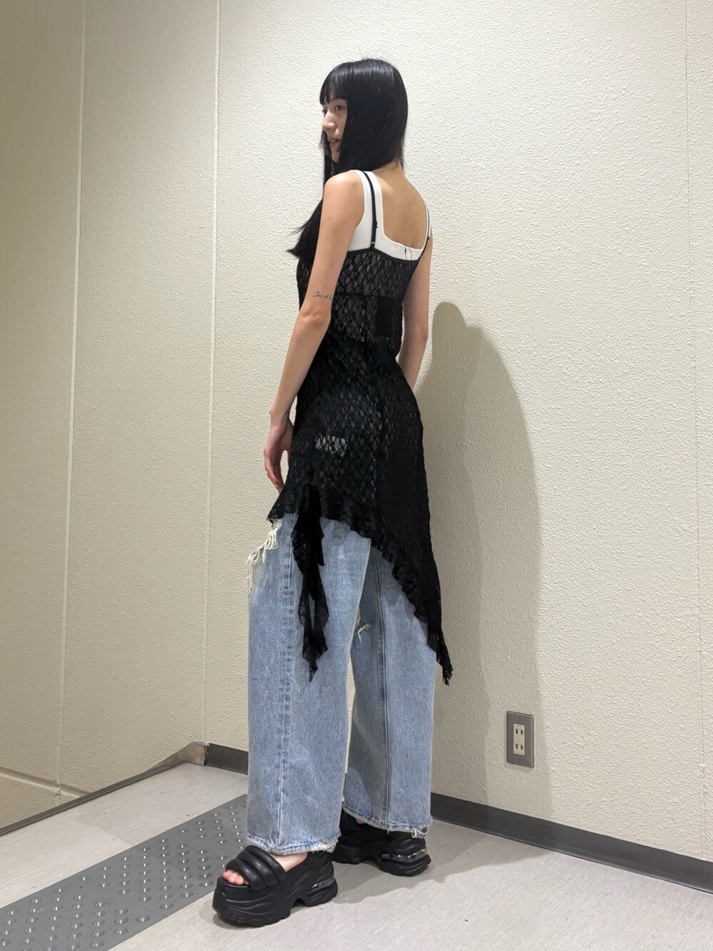 ホワイト系のニット/セーター、ブラック系のワンピース、ブルー系のデニムパンツを着用したレディースの夏コーディネートの4枚目の写真