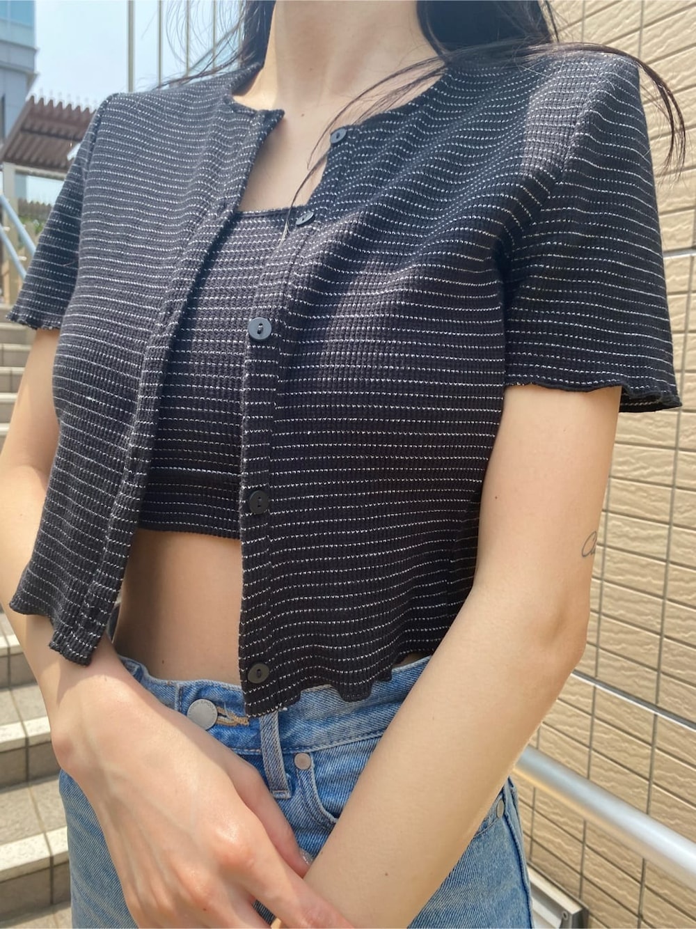 ブラック系のサンダル、ブルー系のデニムパンツ、その他のアンサンブルを着用したレディースの夏コーディネートの4枚目の写真