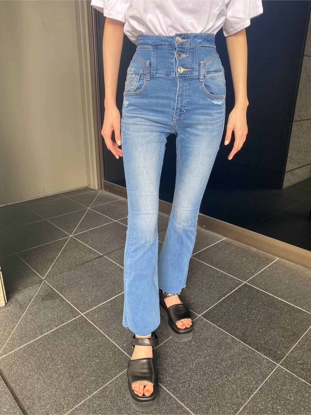 ブラック系のサンダル、ブルー系のデニムパンツ、ホワイト系のTシャツ/カットソーを着用したレディースの夏コーディネートの4枚目の写真