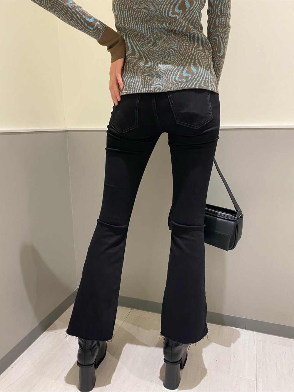 ブラック系のブーツ、ブラック系のハンドバッグ、その他のカーディガン/ボレロを着用したレディースの秋コーディネートの5枚目の写真