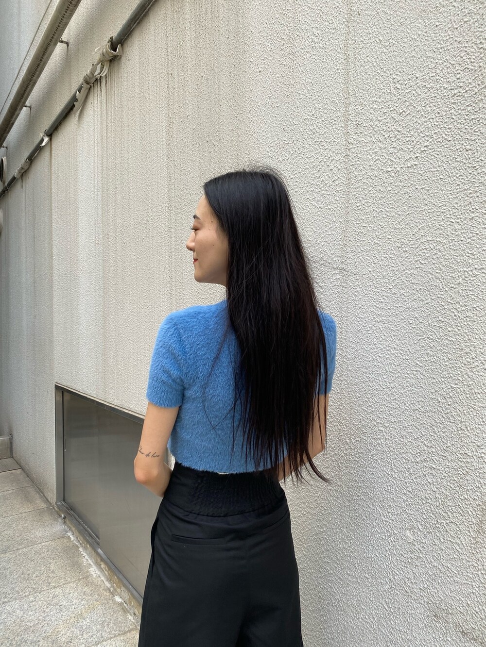 ブラック系のその他パンツ、ホワイト系のハンドバッグ、ブルー系のニット/セーターを着用したレディースの夏コーディネートの8枚目の写真