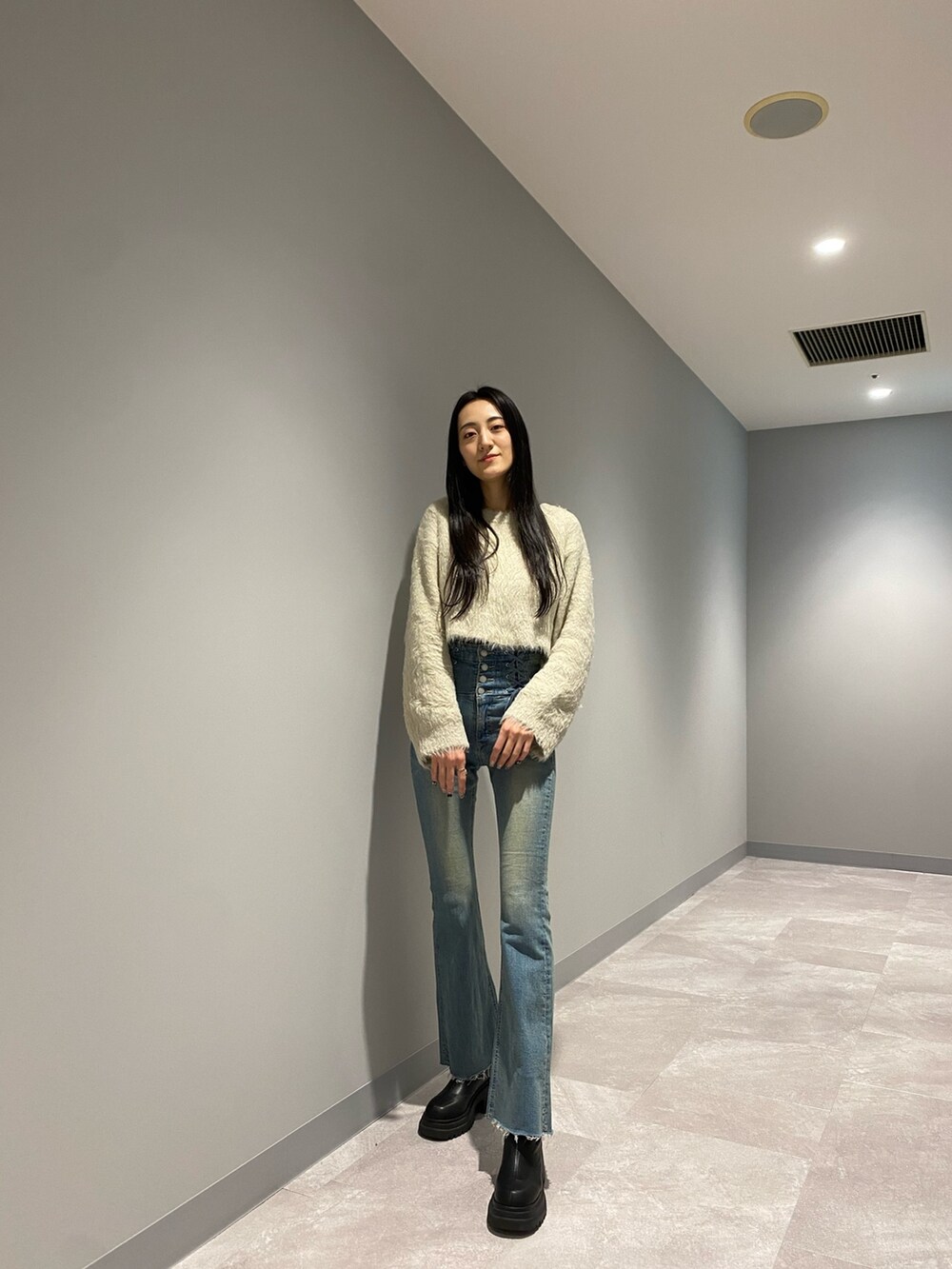 ブラック系のブルゾン、ブルー系のデニムパンツ、ホワイト系のニット/セーターを着用したレディースの冬コーディネートの4枚目の写真