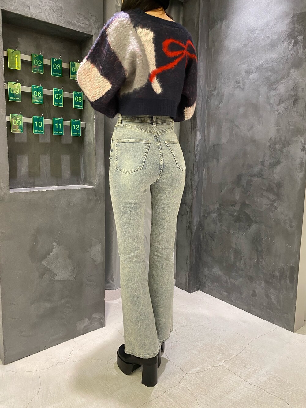 ブルー系のデニムパンツ、ブルー系のニット/セーター、ブラック系のブーツを着用したレディースの秋コーディネートの10枚目の写真