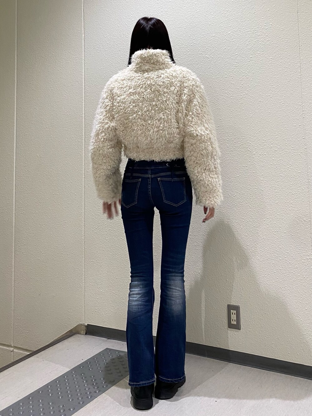 ブルー系のデニムパンツ、ホワイト系のブルゾンを着用したレディースの秋コーディネートの3枚目の写真