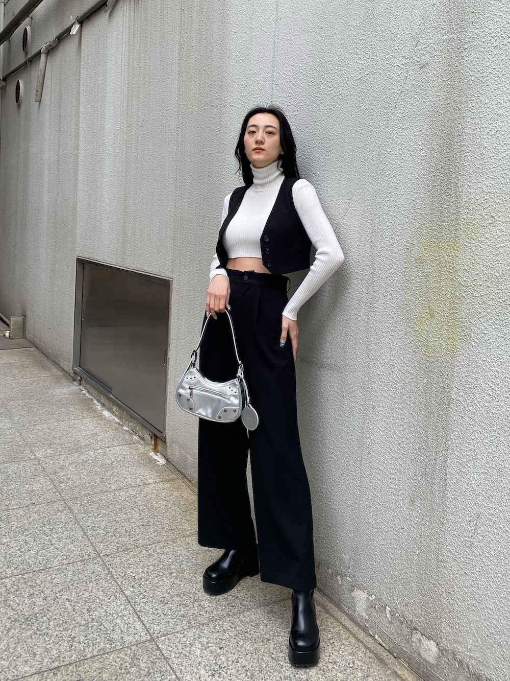 ブラック系のベスト、ブラック系のその他パンツ、ホワイト系のニット/セーターを着用したレディースの春コーディネートの2枚目の写真