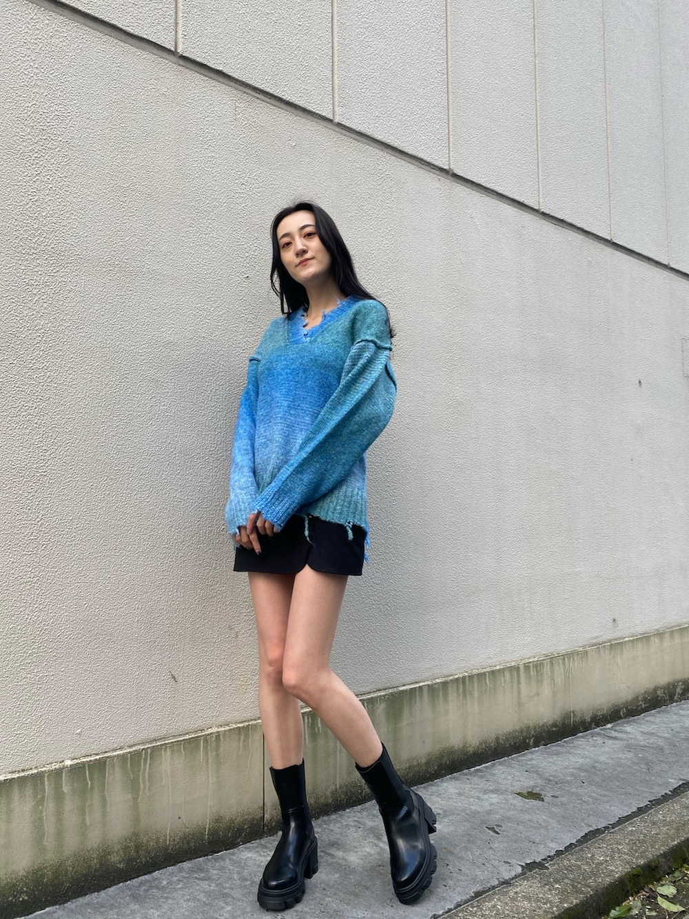 ブルー系のニット/セーター、ブラック系のブーツ、ホワイト系のダウンジャケット/コートを着用したレディースの冬コーディネートの4枚目の写真