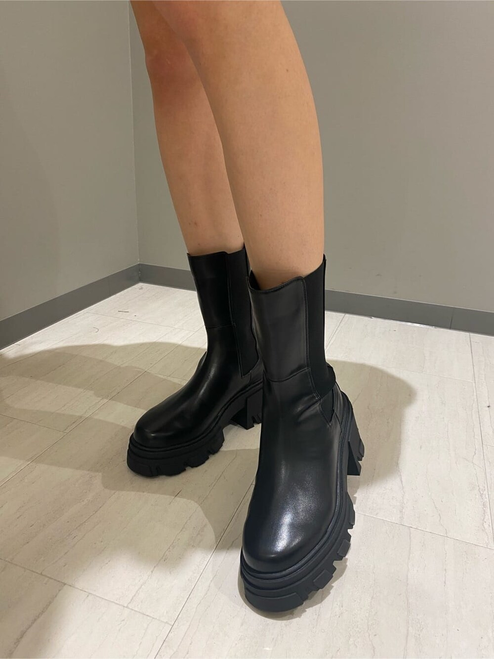 ブラック系のブーツ、ブラック系のハンドバッグ、ホワイト系のニット/セーターを着用したレディースの秋コーディネートの8枚目の写真