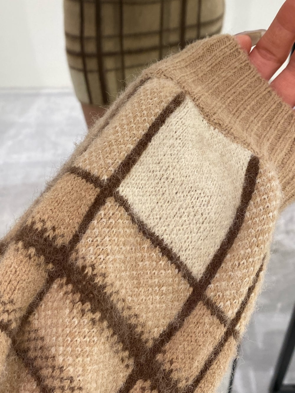 ベージュ系のニット/セーター、ベージュ系のスカート、ブラック系のブーツを着用したレディースの冬コーディネートの5枚目の写真