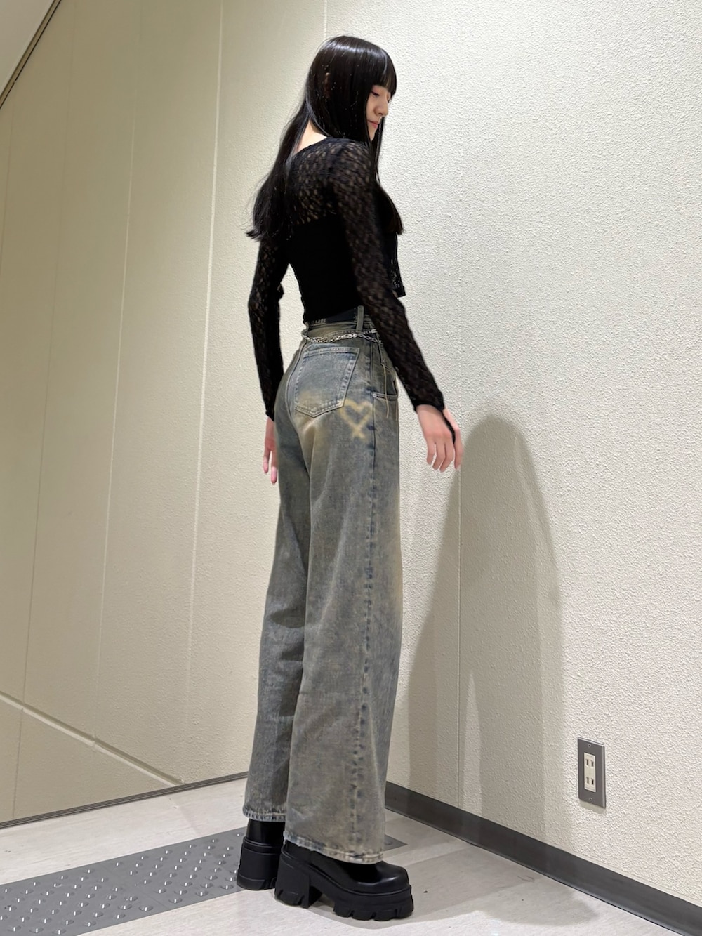 ブルー系のデニムパンツ、ブラック系のTシャツ/カットソー、ブラック系のブーツを着用したレディースの春コーディネートの5枚目の写真