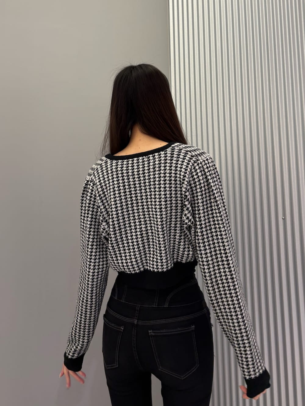 ブラック系のデニムパンツ、ブラック系のニット/セーター、ブラック系のブーツを着用したレディースの秋コーディネートの9枚目の写真