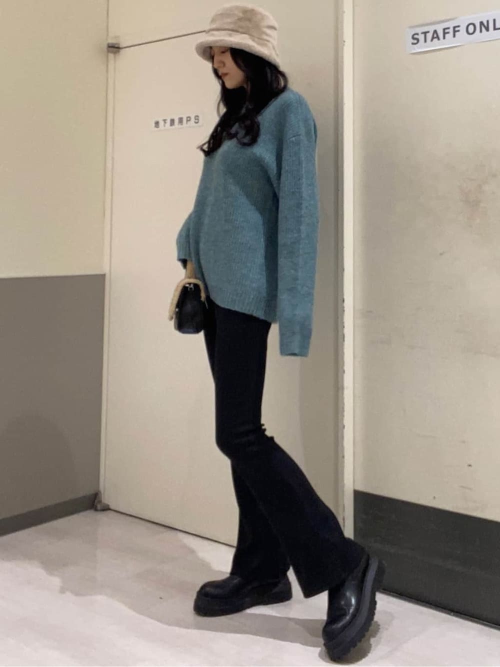 ブラック系のハンドバッグ、ブルー系のニット/セーター、ブラック系のその他パンツを着用したレディースの秋コーディネートの2枚目の写真