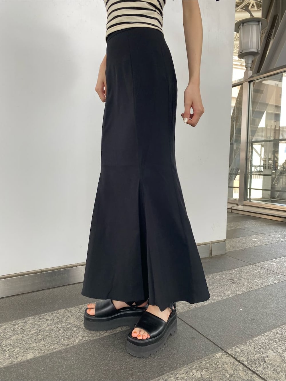 ブラック系のサンダル、ブラック系のスカート、その他のTシャツ/カットソーを着用したレディースの夏コーディネートの4枚目の写真