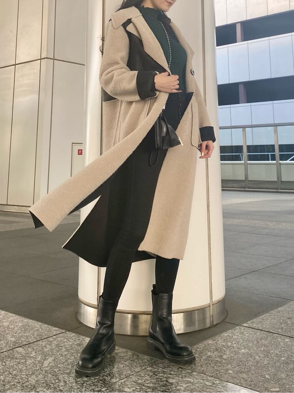 ブラック系のデニムパンツ、ブラック系のムートンコート、ブラック系のショルダーバッグを着用したレディースの冬コーディネートの4枚目の写真