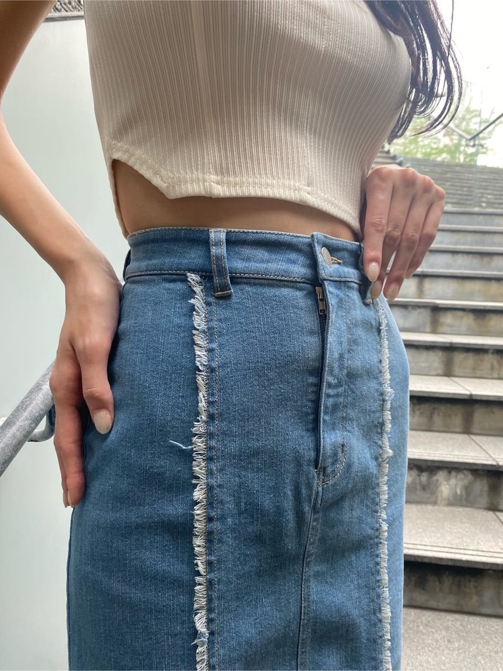 ブルー系のスカート、ホワイト系のタンクトップ、ブラック系のサンダルを着用したレディースの夏コーディネートの6枚目の写真